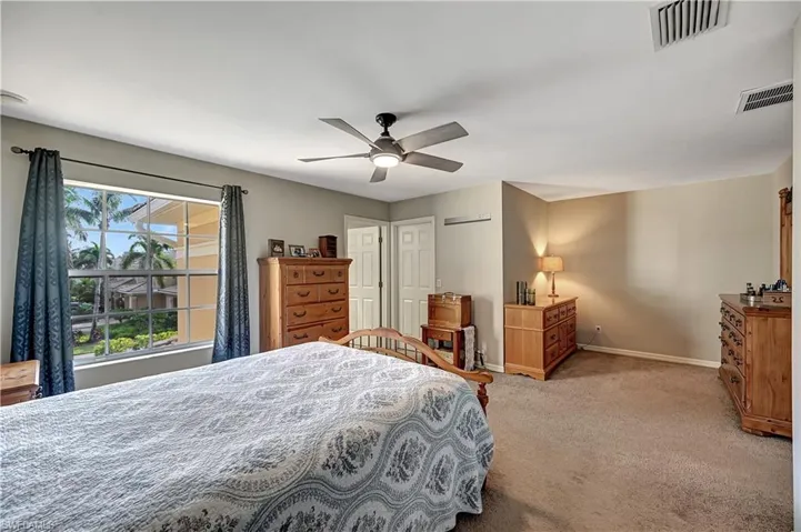 Bedroom with ceiling fan and light carpet