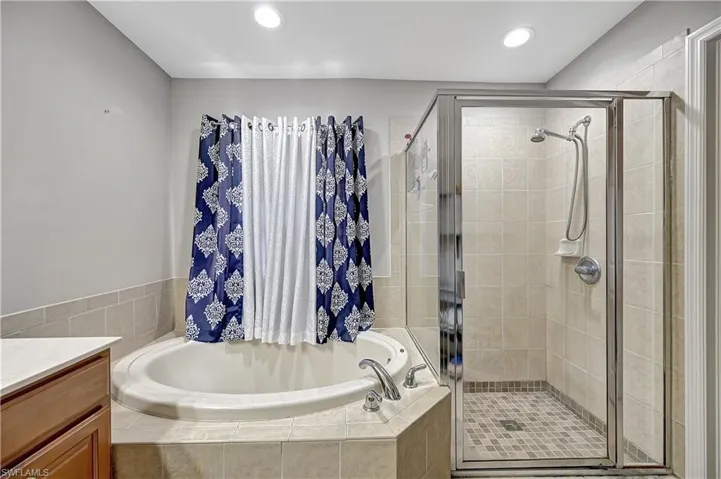 Bathroom featuring vanity and shower with separate bathtub