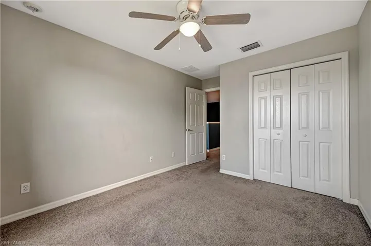 Unfurnished bedroom featuring ceiling fan, carpet floors, and a closet