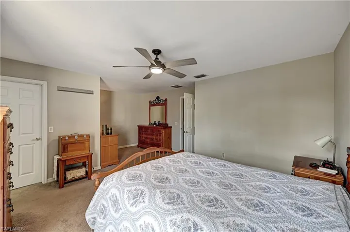 Carpeted bedroom featuring ceiling fan