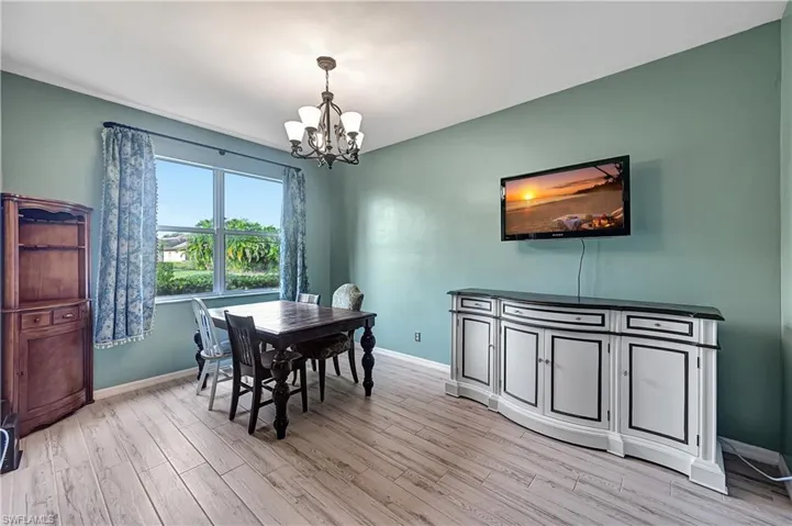 Dining area featuring a notable chandelier and light wood-type flooring
