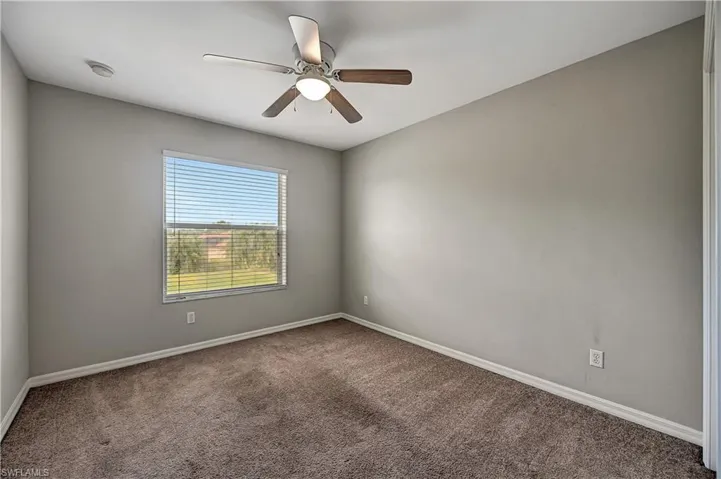 Unfurnished room featuring ceiling fan and carpet floors