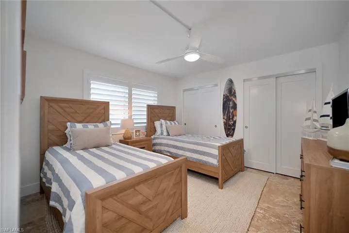Bedroom with multiple closets and ceiling fan