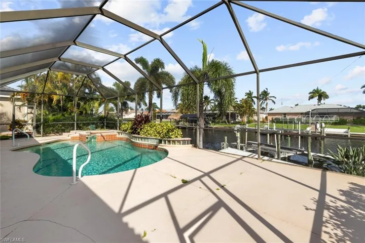 View of swimming pool with a boat dock, a water view, a lanai, and a patio area