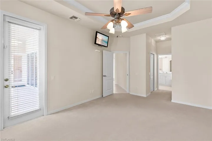 master bedroom  room featuring ceiling fan, a tray ceiling, and crown molding