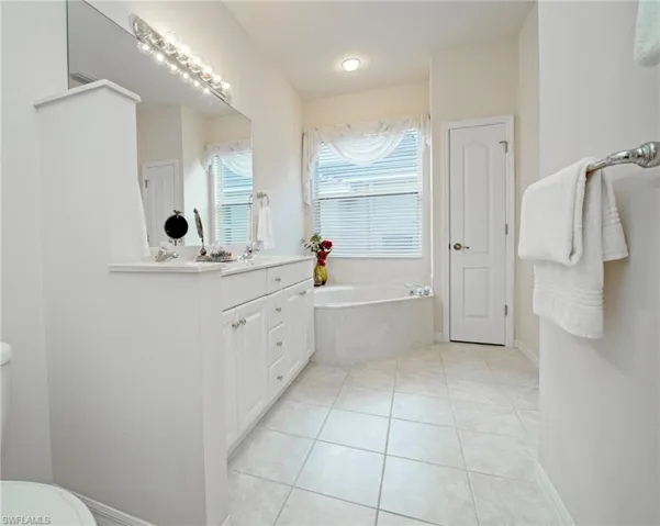 Bathroom featuring vanity, tile patterned floors, and a bathing tub
