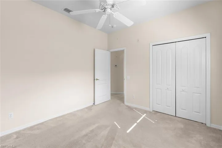 Unfurnished bedroom with a closet, ceiling fan, and light colored carpet