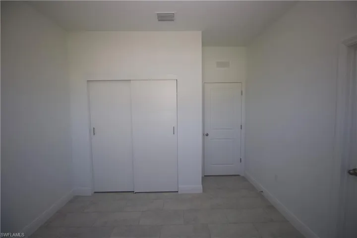 Bedroom featuring a closet and light tile patterned flooring