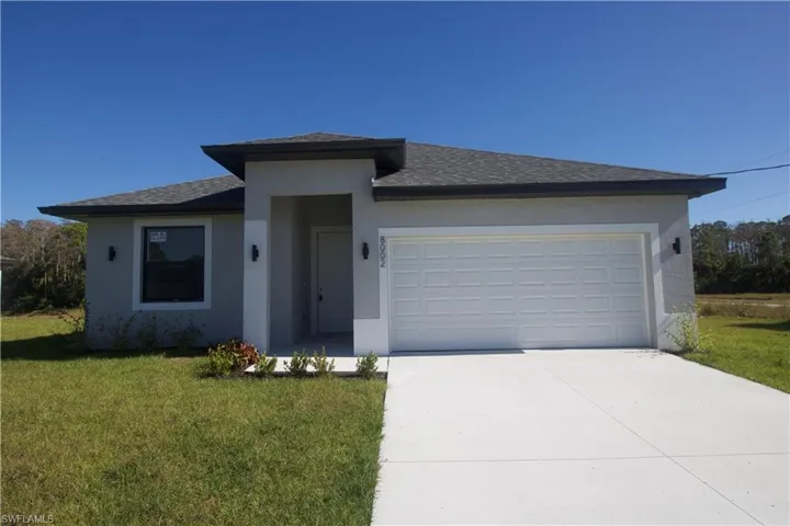 View of front of home featuring a front yard and a two car garage
