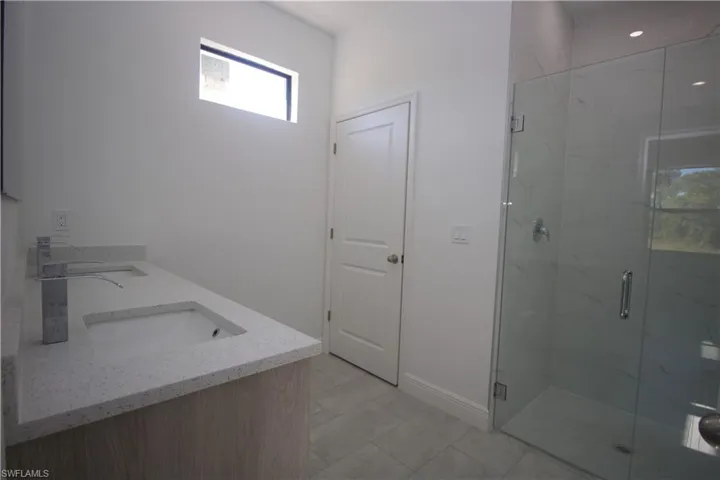 Master Bathroom with vanity and a shower with door