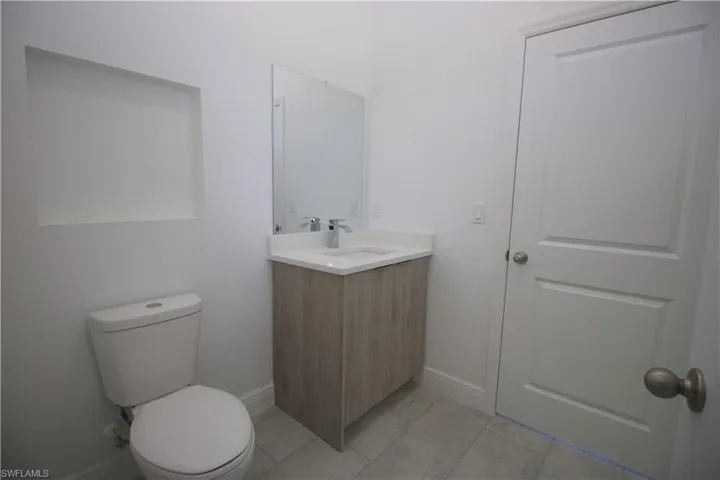 Jack & Jill style Bathroom with a tile shower, tile patterned floors, vanity, and toilet