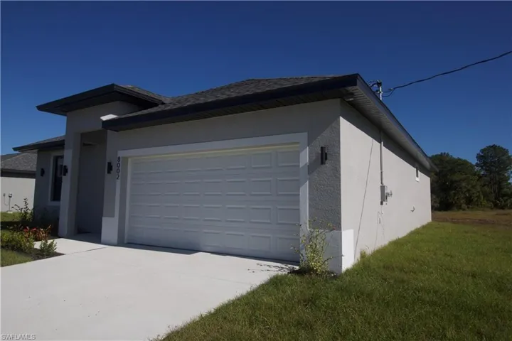 View of side of property with a yard and a two car garage
