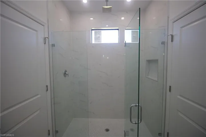 Jack & Jill style Bathroom with a tile shower, tile patterned floors, vanity, and toilet