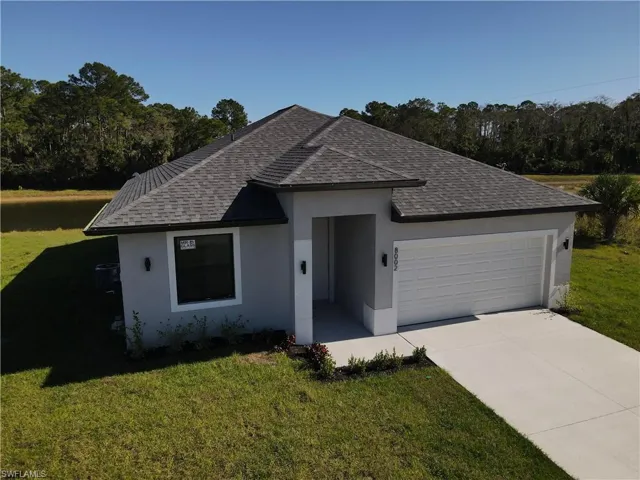 Single story home with a front yard and a two car garage