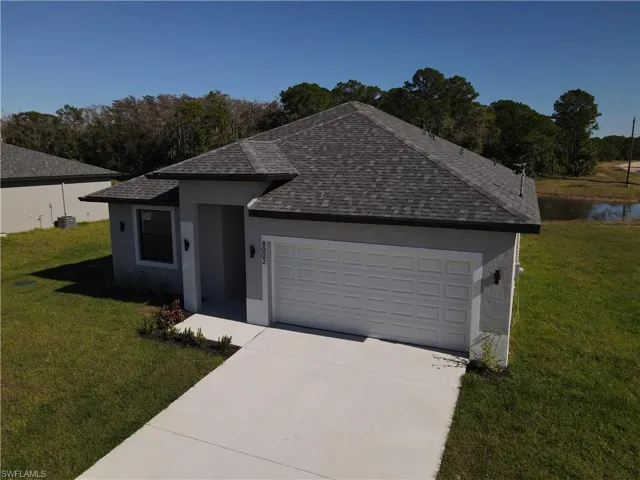 Single story home featuring a water view, a front yard, and a two car garage