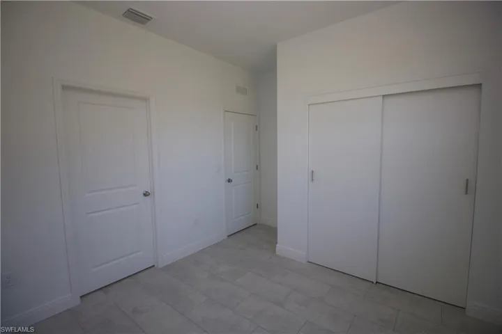 Bedroom featuring a closet and light tile patterned flooring