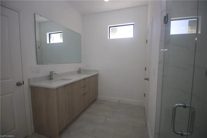 Master Bathroom featuring plenty of natural light, vanity, and a shower with door