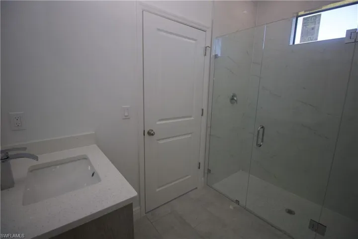 Jack & Jill style Bathroom with a tile shower, tile patterned floors, vanity, and toilet