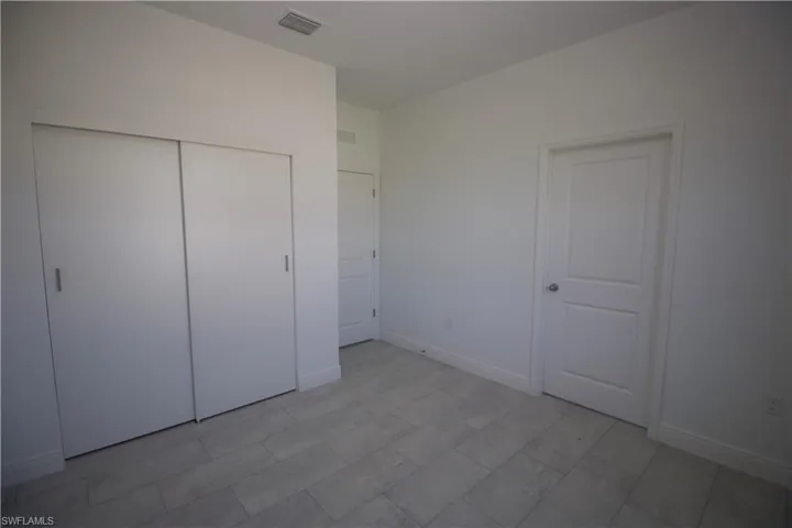 Bedroom featuring a closet and light tile patterned flooring