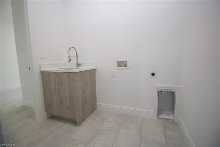 Laundry room with washer hookup, electric dryer hookup, and sink