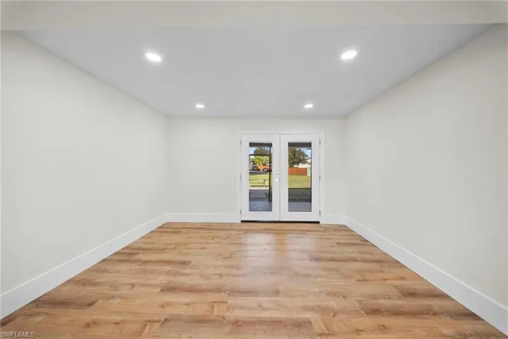 Unfurnished room featuring french doors, light wood-type flooring, and recessed lighting