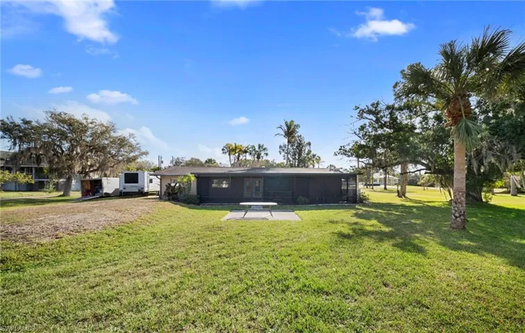 Rear view of house with a lawn and a sunroom