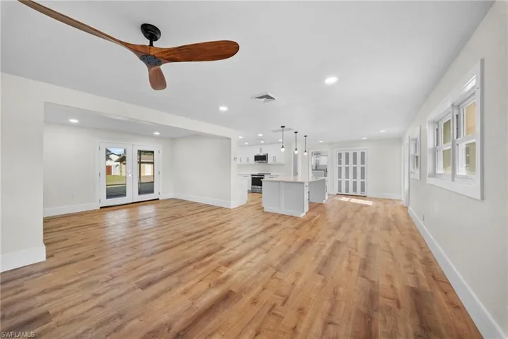 Unfurnished living room featuring a ceiling fan, french doors, light wood-style floors, and recessed lighting