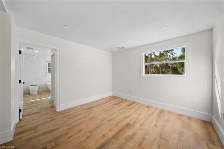 Empty room with light wood-style floors and recessed lighting