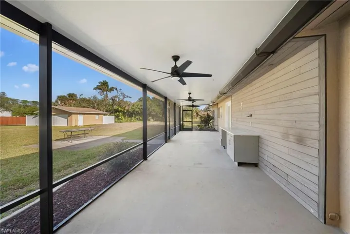 Unfurnished sunroom featuring a ceiling fan