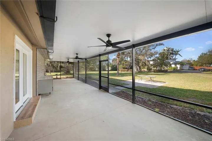 Unfurnished sunroom with a patio area and a ceiling fan