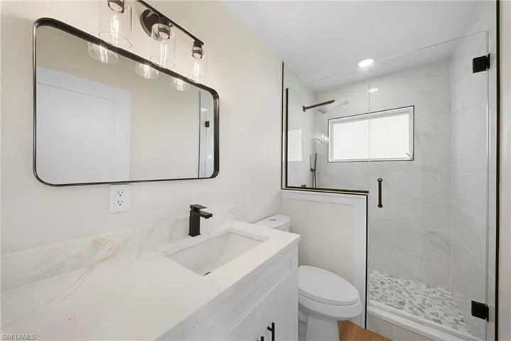 Bathroom with vanity, a stall shower, and recessed lighting
