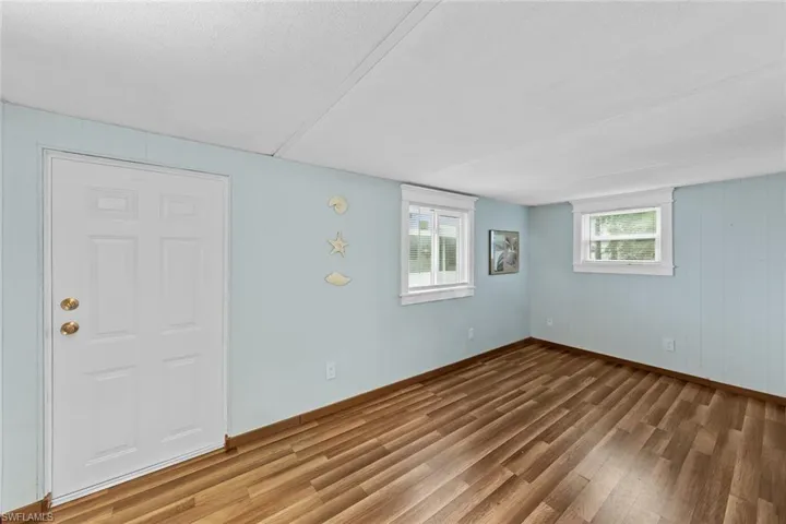 Unfurnished room featuring hardwood / wood-style flooring and a textured ceiling