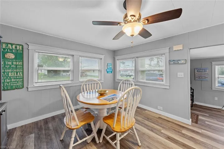 Dining room featuring hardwood / wood-style flooring, ceiling fan, and wood walls