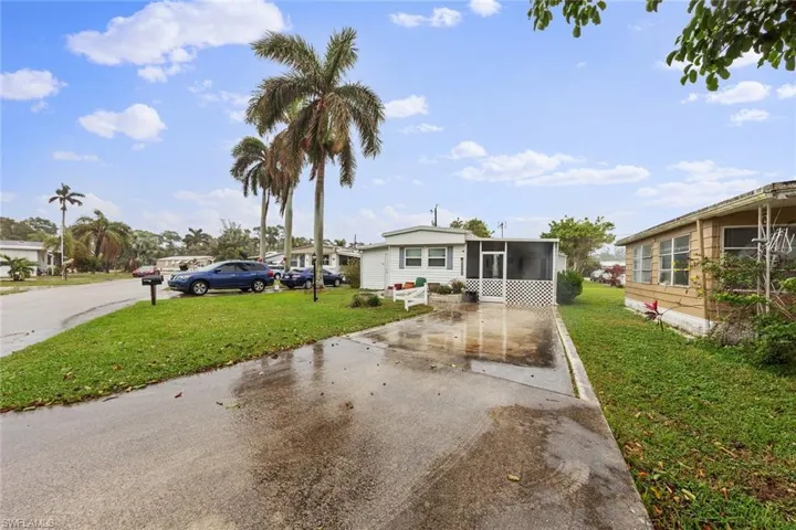 View of front of property with a sunroom and a front yard