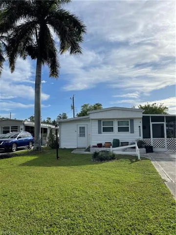 View of front of home with a front lawn and a sunroom