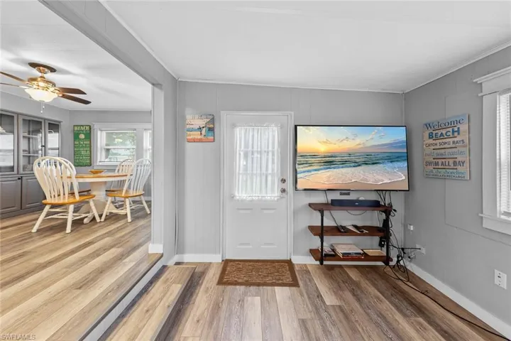 Entryway featuring hardwood / wood-style floors, ceiling fan, and crown molding