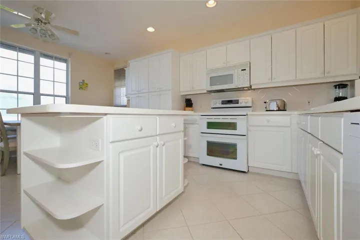 Kitchen featuring white cabinetry and white appliances