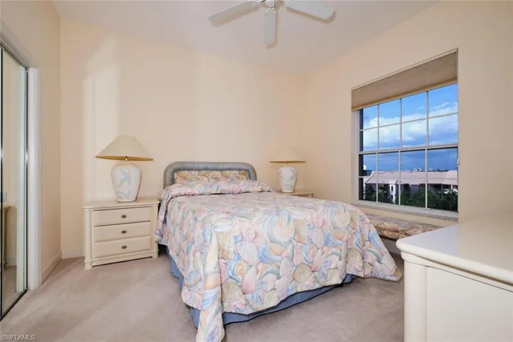 Carpeted bedroom with a closet and ceiling fan