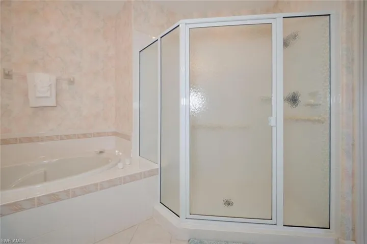Bathroom featuring tile patterned floors and plus walk in shower