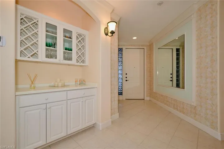 Hall with light tile patterned floors and ornamental molding