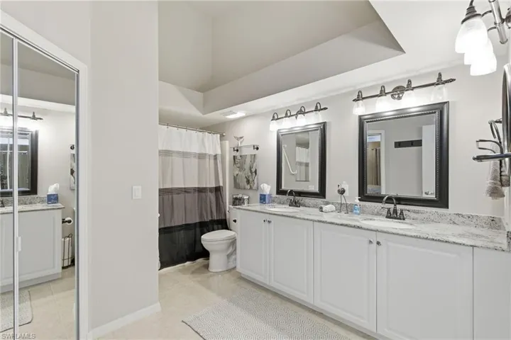 Dual sinks with granite countertops and walk-in closet