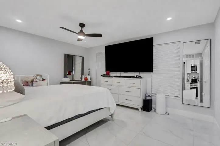 Spacious room featuring light-toned walls and large format tile flooring