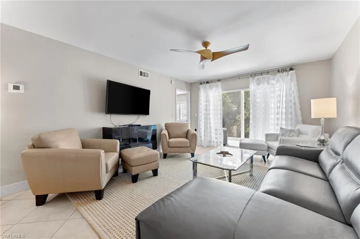 Living area with baseboards, ceiling fan, visible vents, and light tile patterned floors