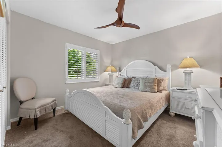 Carpeted bedroom featuring a ceiling fan and baseboards