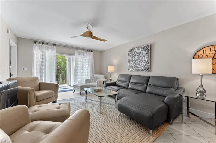 Living area featuring baseboards, a ceiling fan, and light tile patterned floors
