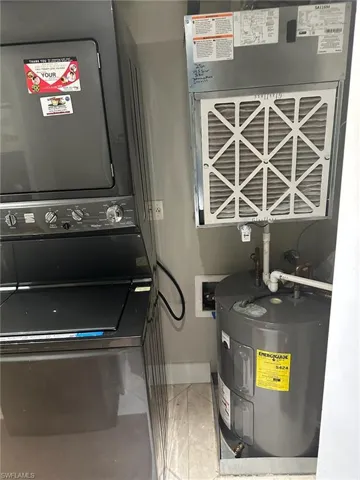 Utilities featuring electric water heater and stacked washer / drying machine