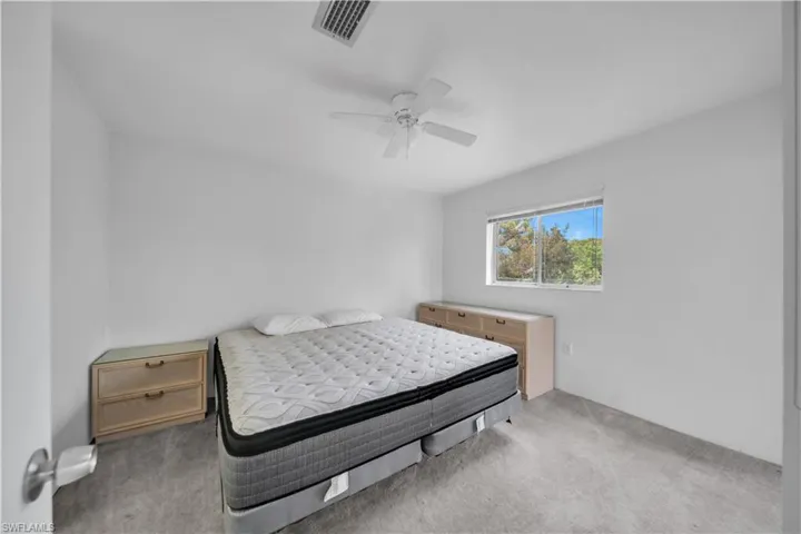Carpeted bedroom featuring ceiling fan