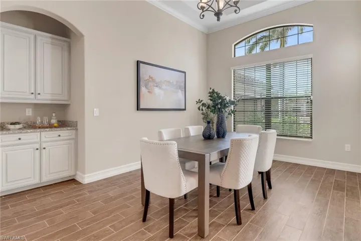 Dining area featuring wood tiled floor, crown molding, and baseboards