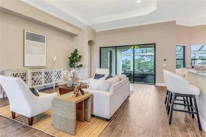 Living room featuring wood tiled floor, crown molding, arched walkways, and baseboards