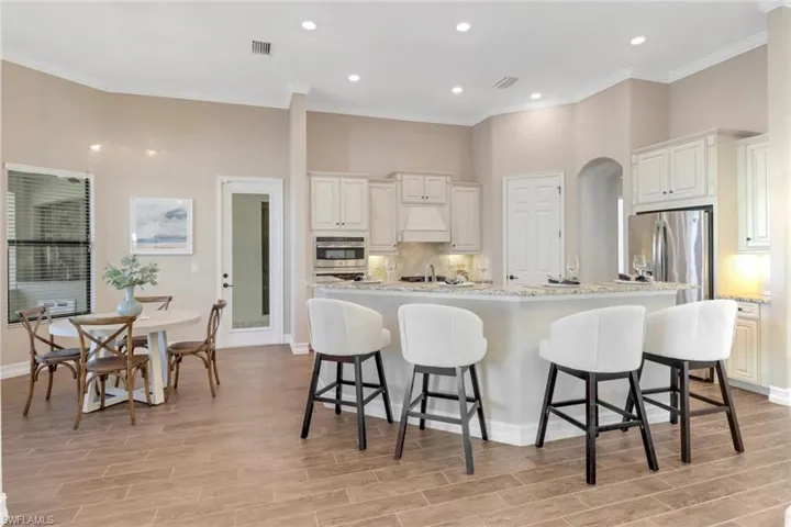 Kitchen with light wood-style floors, a kitchen bar, visible vents, and stainless steel appliances
